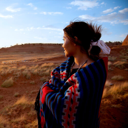 woman in a blanket standing in the desert